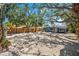 Charming home exterior with gravel landscaping, mature trees, and a newly stained fence offering privacy at 8234 Midnight Pass Rd, Sarasota, FL 34242