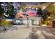 Charming home featuring a gravel backyard with mature trees, wooden fence, and a screened in porch area at dusk at 8234 Midnight Pass Rd, Sarasota, FL 34242