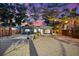 Stunning exterior shot of home with professional landscaping, string lights, and sunset sky at 8234 Midnight Pass Rd, Sarasota, FL 34242