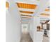 Hallway view to modern kitchen featuring wood ceilings, white walls, and views of the pool at 8234 Midnight Pass Rd, Sarasota, FL 34242