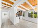 Hallway view to modern kitchen featuring wood ceilings, white walls, and wood-look tile flooring at 8234 Midnight Pass Rd, Sarasota, FL 34242