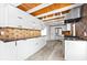 Modern kitchen with white cabinets, stainless steel appliances, geometric backsplash, and wood-look ceiling at 8234 Midnight Pass Rd, Sarasota, FL 34242