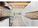 Bright kitchen features modern appliances, white cabinets, striking backsplash, and wood plank ceiling at 8234 Midnight Pass Rd, Sarasota, FL 34242