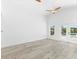 Bright living room boasts wood floors, white walls, a fan, and view of the backyard pool at 8234 Midnight Pass Rd, Sarasota, FL 34242