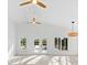 Bright living room boasts three fans, high vaulted ceilings, light wood floors, and view to the outdoors at 8234 Midnight Pass Rd, Sarasota, FL 34242