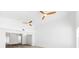 Bright living room with white walls, hardwood floors, and three fans on a high vaulted ceiling at 8234 Midnight Pass Rd, Sarasota, FL 34242