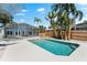 Backyard pool with screened lanai, turquoise water, and tropical landscaping at 8234 Midnight Pass Rd, Sarasota, FL 34242