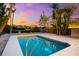 Backyard pool with turquoise water, bordered by tropical landscaping, under a colorful sunset sky at 8234 Midnight Pass Rd, Sarasota, FL 34242