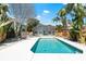 Backyard pool with turquoise water, screened-in lanai and lush landscaping at 8234 Midnight Pass Rd, Sarasota, FL 34242