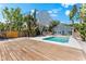 Backyard pool with turquoise water, wooden deck and screened-in lanai at 8234 Midnight Pass Rd, Sarasota, FL 34242