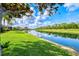 Lush backyard with a tranquil lake offers a scenic view and a peaceful setting at 8930 Bloomfield Blvd, Sarasota, FL 34238