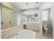 Bright bathroom featuring walk-in shower with dual showerheads, double vanity and soaking tub at 8930 Bloomfield Blvd, Sarasota, FL 34238