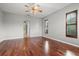 Spacious bedroom featuring hardwood floors, ceiling fan, and natural light from two windows at 8930 Bloomfield Blvd, Sarasota, FL 34238