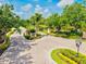 Inviting community entrance with manicured landscaping, sign, and serene pond view at 8930 Bloomfield Blvd, Sarasota, FL 34238