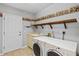 Laundry room featuring washer, dryer, shelving, and utility sink at 8930 Bloomfield Blvd, Sarasota, FL 34238