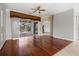 Bright living room boasts hardwood floors, ceiling fan, and sliding glass doors to outdoor space at 8930 Bloomfield Blvd, Sarasota, FL 34238