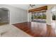 Light-filled living area featuring wood floors, a ceiling fan, and a large glass door overlooking the pool at 8930 Bloomfield Blvd, Sarasota, FL 34238