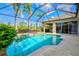 Sparkling in-ground pool with a waterfall feature and lush landscaping creates a backyard oasis at 8930 Bloomfield Blvd, Sarasota, FL 34238