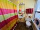 Bright, yellow bathroom with colorful shower curtain and floral accents at 1019 10Th W Ave, Bradenton, FL 34205