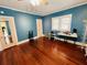 Spacious bedroom featuring hardwood floors, blue accent walls, and natural light from the windows at 1019 10Th W Ave, Bradenton, FL 34205