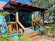 Exterior view of a colorful home with a wooden front porch and vibrant mosaic details at 1019 10Th W Ave, Bradenton, FL 34205