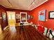 Vibrant art gallery with hardwood floors and red walls adorned with diverse and colorful paintings at 1019 10Th W Ave, Bradenton, FL 34205