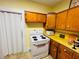 Kitchen with an electric range, yellow counters, and wood cabinets with white hardware at 1019 10Th W Ave, Bradenton, FL 34205