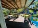 Covered patio with view of backyard shed, lush foliage and outdoor seating area at 1019 10Th W Ave, Bradenton, FL 34205