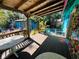 Covered wood patio showing outdoor seating area with string lights and lush garden at 1019 10Th W Ave, Bradenton, FL 34205