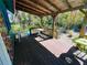 Covered wood patio showing outdoor seating area with string lights and lush garden at 1019 10Th W Ave, Bradenton, FL 34205