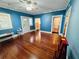 Large blue room with hardwood floors, bright windows, and a white door at 1019 10Th W Ave, Bradenton, FL 34205