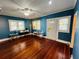 Large blue room with wooden floors, a white door, and plenty of light at 1019 10Th W Ave, Bradenton, FL 34205