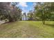 Spacious grassy backyard is enclosed with a wood privacy fence and mature trees at 102 28Th W St, Bradenton, FL 34205