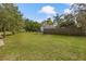 Large grassy backyard with a wood privacy fence and mature trees at 102 28Th W St, Bradenton, FL 34205