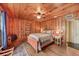 Unique bedroom featuring wood-paneled walls and a ceiling fan at 102 28Th W St, Bradenton, FL 34205