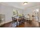 Cozy dining area with a wood table set for four, hardwood floors, and bright window at 102 28Th W St, Bradenton, FL 34205