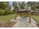 A gazebo with outdoor furniture sits on a stone patio in the backyard at 102 28Th W St, Bradenton, FL 34205