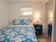Cozy bedroom with blue patterned bedding, wood floors, mirrored closet, and a small window for natural light at 10315 Cortez W Rd # 32-7, Bradenton, FL 34210