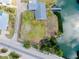 An aerial view of the home shows a waterfront property with a private dock and lush landscaping at 104 Pops Ln, Nokomis, FL 34275