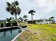 The back of the property features a waterfront view and palm trees at 104 Pops Ln, Nokomis, FL 34275