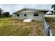 Back of home with green exterior features some materials needing repair and fenced in yard at 104 Pops Ln, Nokomis, FL 34275