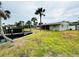 Back of home, with large lawn, mature palm trees, access to waterfront, and green exterior at 104 Pops Ln, Nokomis, FL 34275