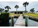 Backyard and dock offer a waterfront lifestyle with palm trees at 104 Pops Ln, Nokomis, FL 34275