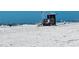 Wide sandy beach with lifeguard station and flags visible on the coastline at 104 Pops Ln, Nokomis, FL 34275