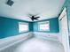 Bedroom with blue walls, two windows with blinds, a ceiling fan, and white trim at 104 Pops Ln, Nokomis, FL 34275
