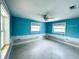 Bedroom with blue walls, two windows with blinds, a ceiling fan, and white trim at 104 Pops Ln, Nokomis, FL 34275