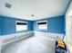 Bright bedroom featuring blue walls, and natural light from two windows at 104 Pops Ln, Nokomis, FL 34275