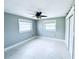 Large bedroom featuring two windows, a ceiling fan, neutral paint, white trim, and closet at 104 Pops Ln, Nokomis, FL 34275