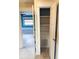 Hallway closet with white shelves and white trim leading into another room at 104 Pops Ln, Nokomis, FL 34275