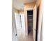 Hallway closet with white shelves and white trim leading into another room at 104 Pops Ln, Nokomis, FL 34275
